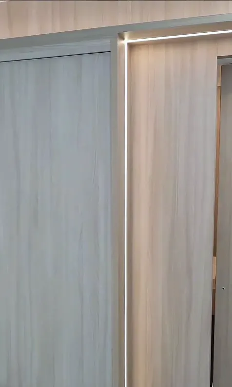 Painel e porta em madeira clara com perfil de LED vertical embutido