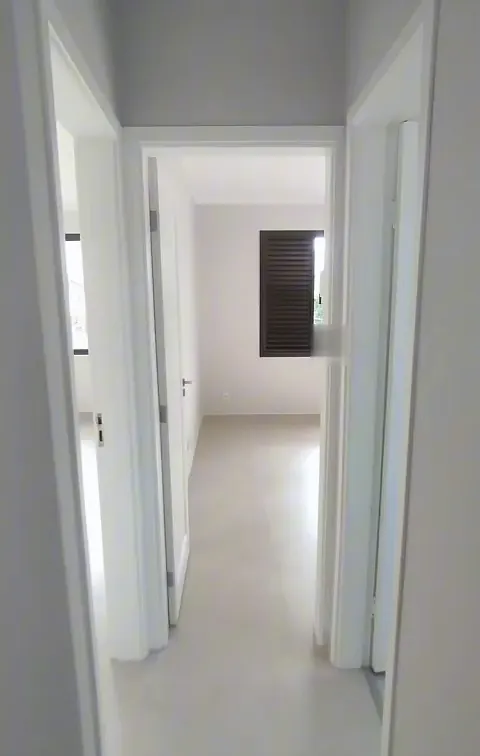 Corredor com portas brancas abertas para os quartos