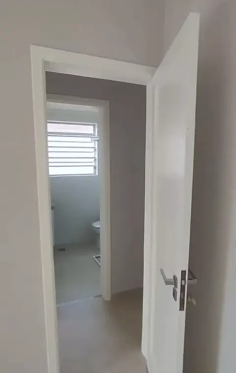Porta branca aberta para o banheiro reformado